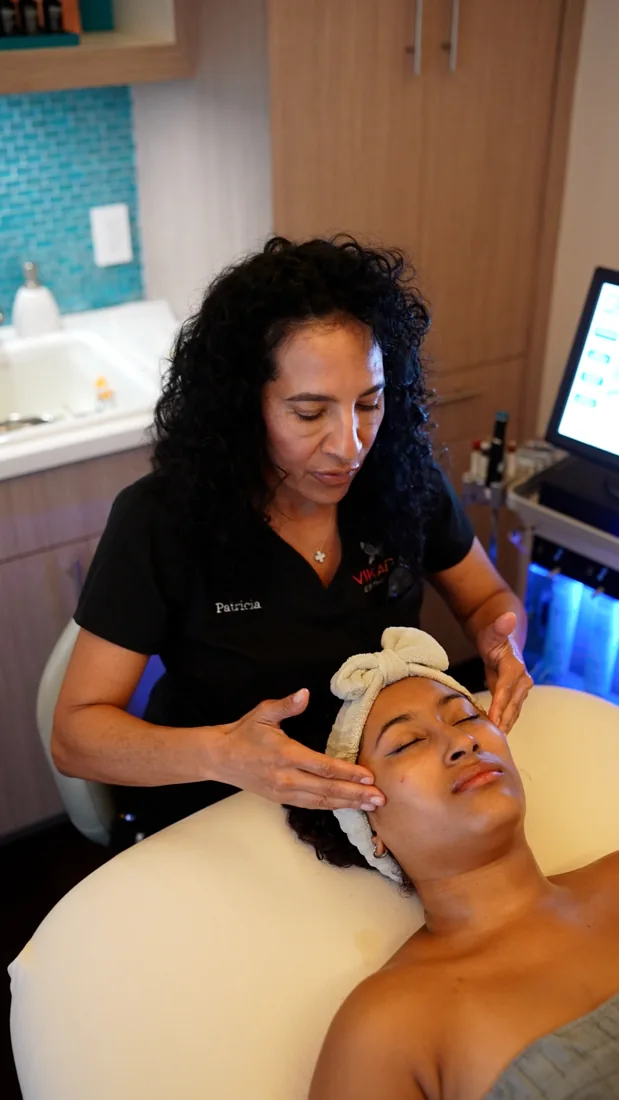 A clinician preparing a facial treatment at VIKARA