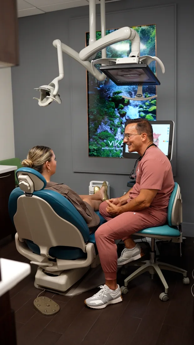 Dr. Julio speaking with a patient in a dental chair