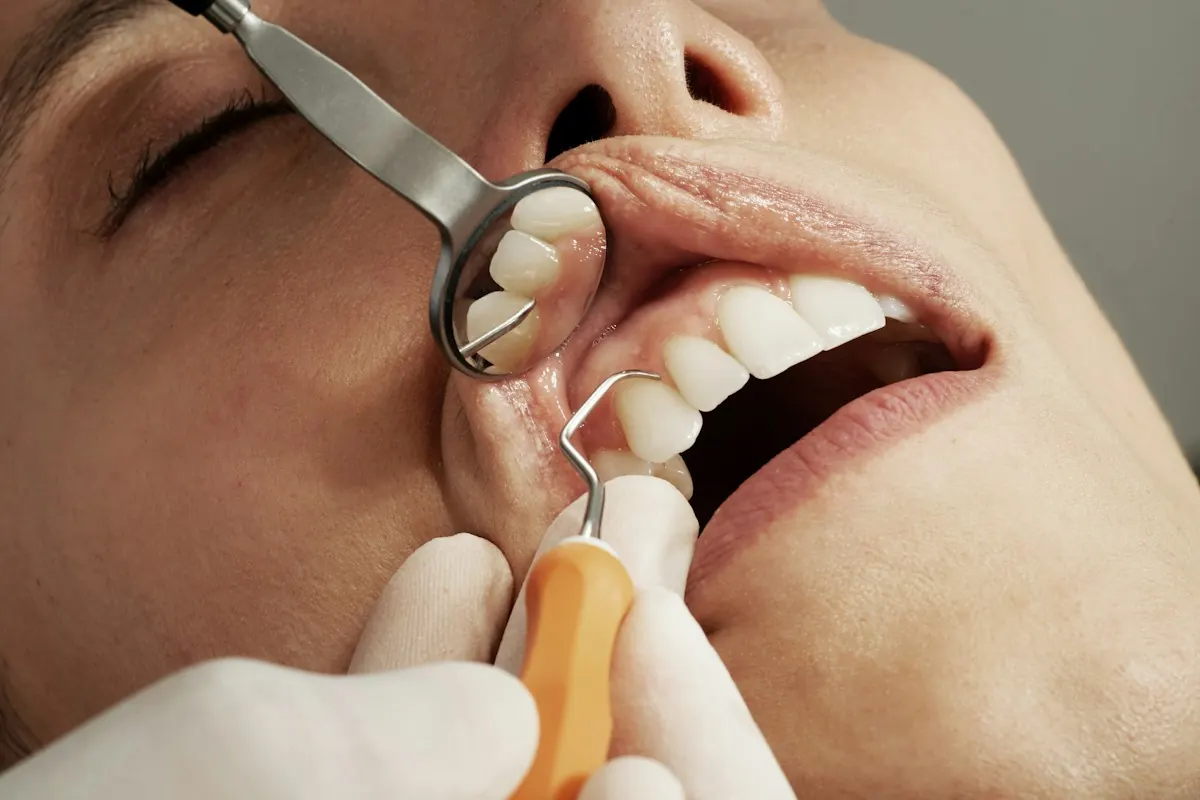 A hygienist working with a mirror and scaler