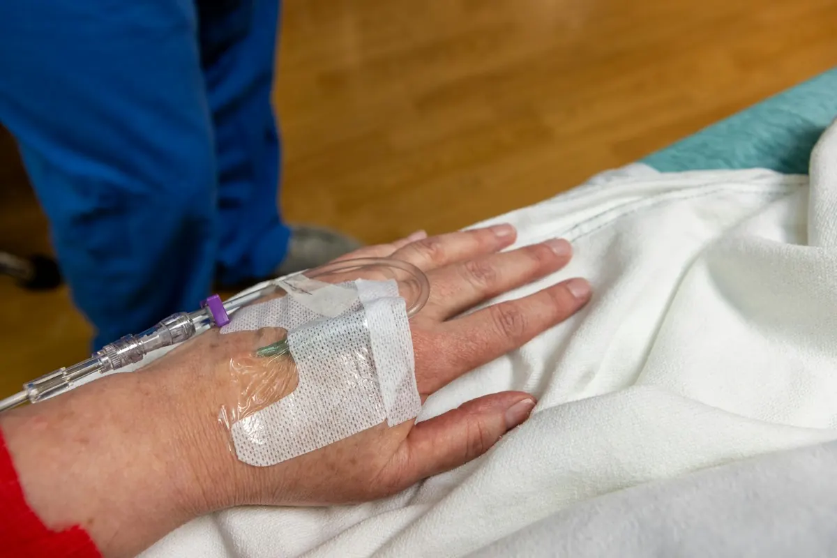 An infusion line taped in place on the hand