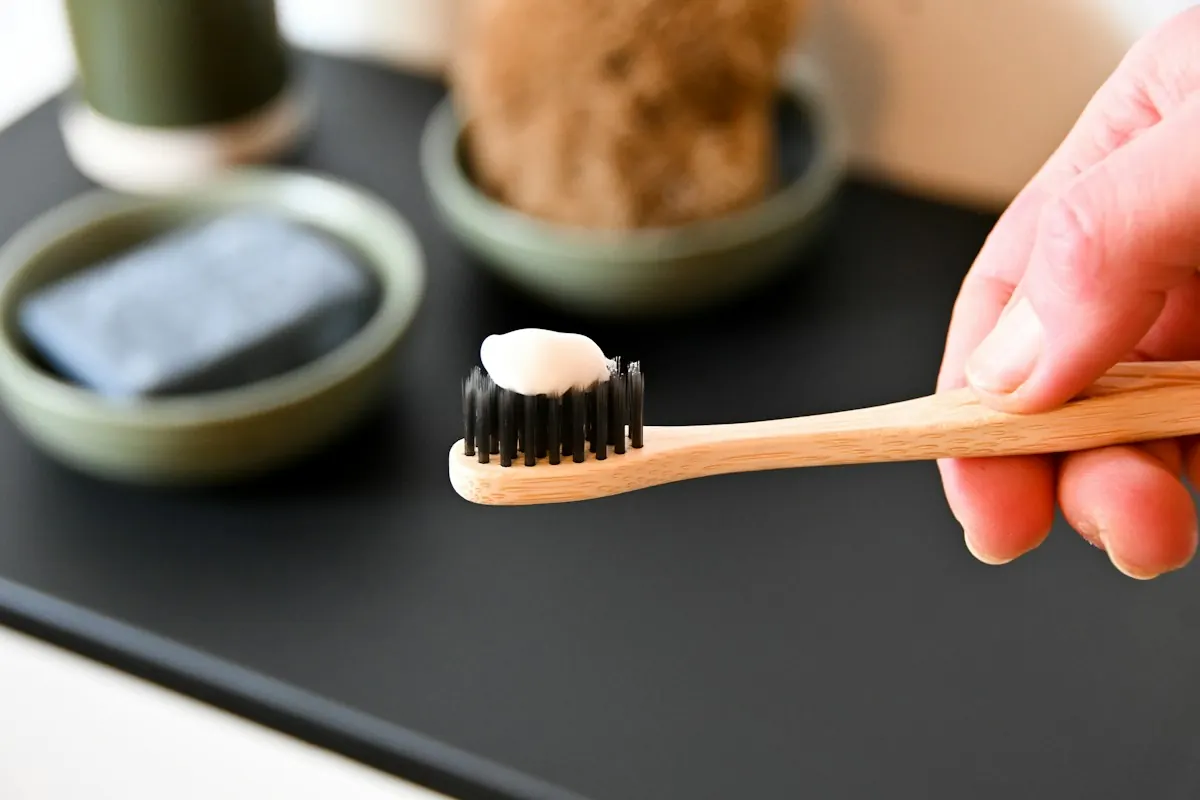 A toothbrush and paste set out on a warm countertop