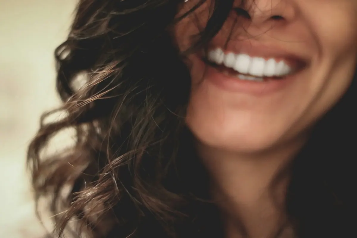 A woman smiling openly in warm daylight